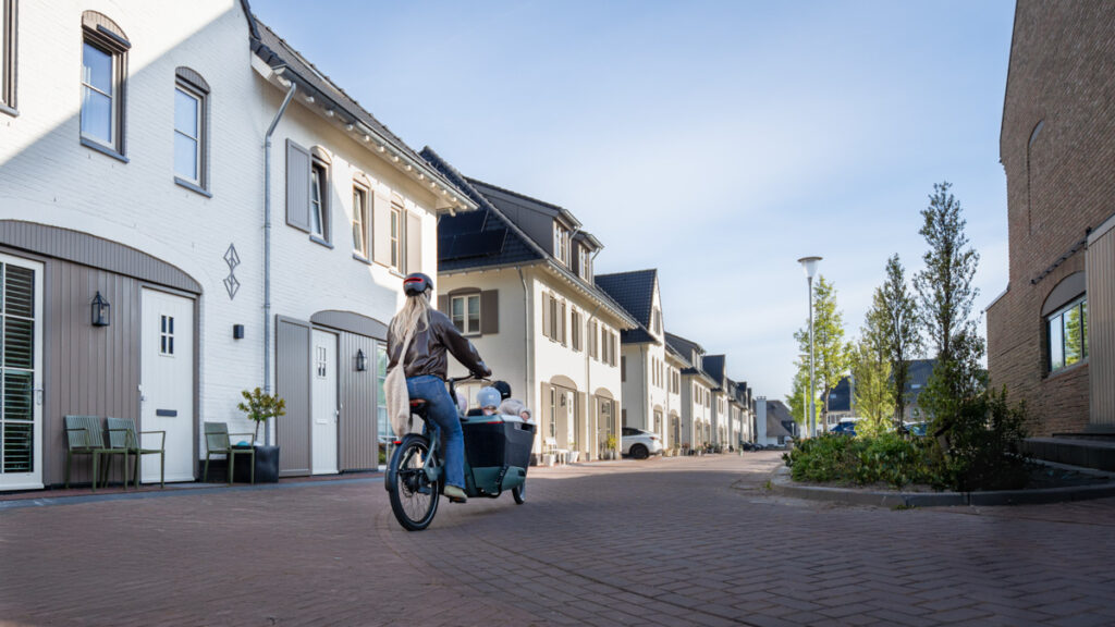 A mum cycles down the street with her family on the Lovens Explorer 2